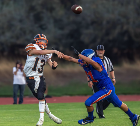 Photo by Kathy Aney. Irrigon quarterback Colton Akers (13) throws the ball ad J Rincon-Gonzales defends on Sept. 5, 2025, in Umatilla