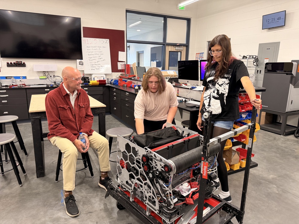 Students Wyatt and Soraya Rincon showing Rep. Greg Smith their team robot
