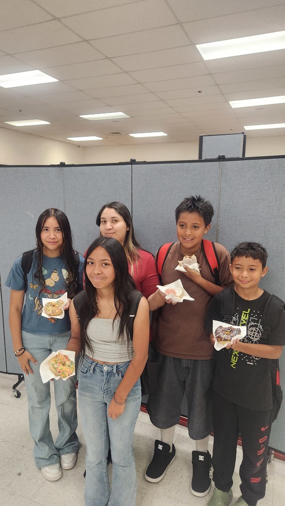 Students enjoying donuts with their family member