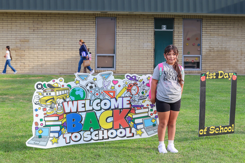 Student taking photo in front of welcome back signs