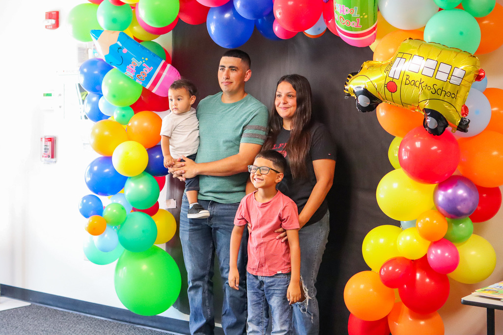 family taking photo at photo backdrop