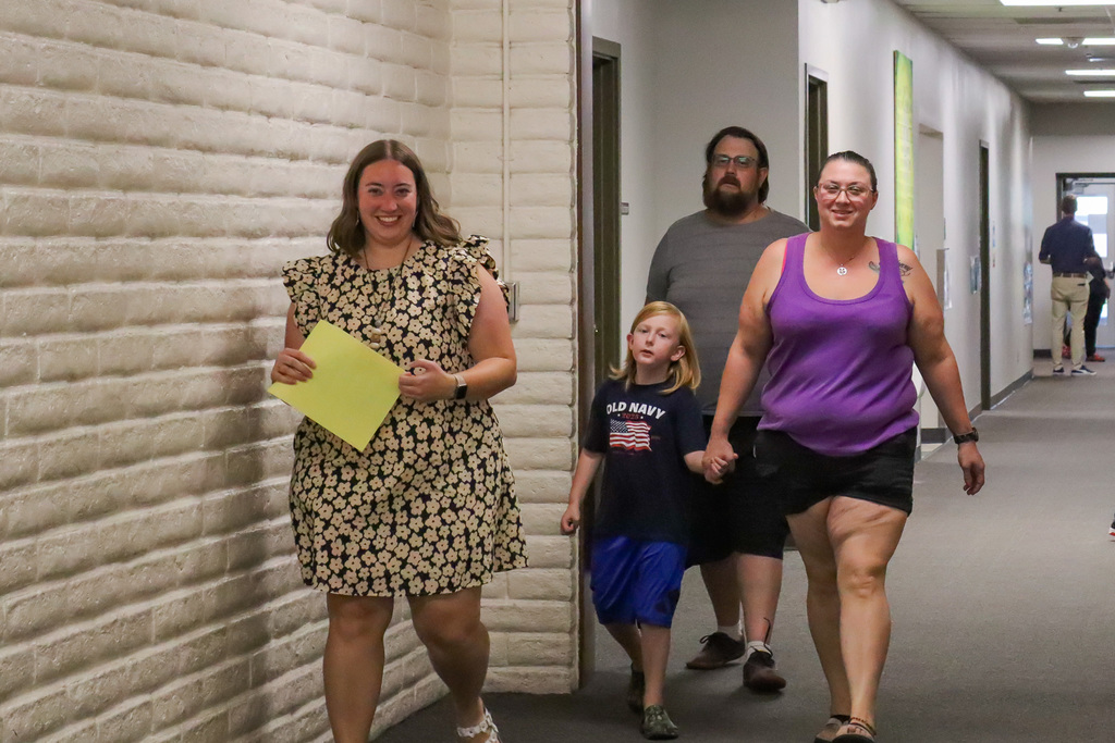 family walking down the hall with vice principal Lorence