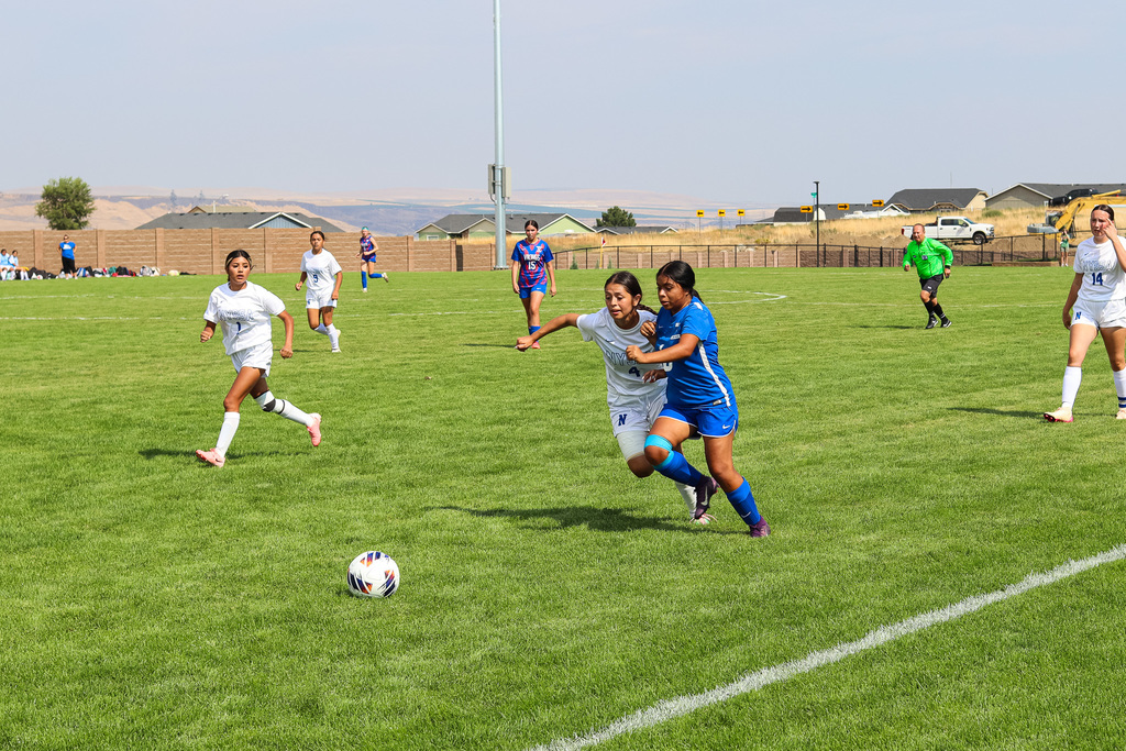 high school soccer athlete and opponent racing towards the ball