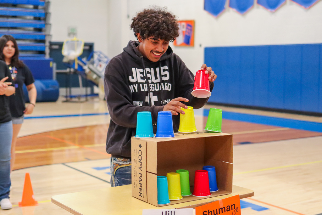 student playing cup stacking game