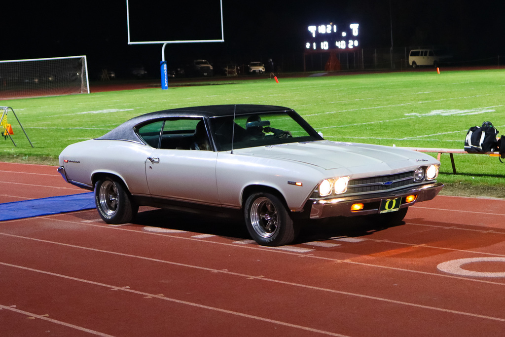 Photo of princess being drove on the field in a vintage car