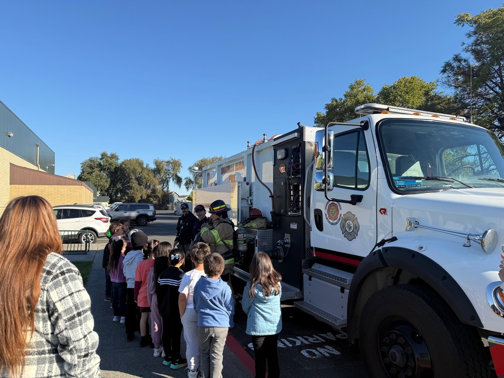 students meeting with another firefighter and learning about their gear