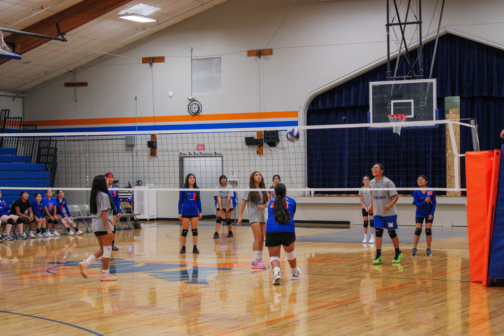 Volleyball players playing a game of volleyball against each other