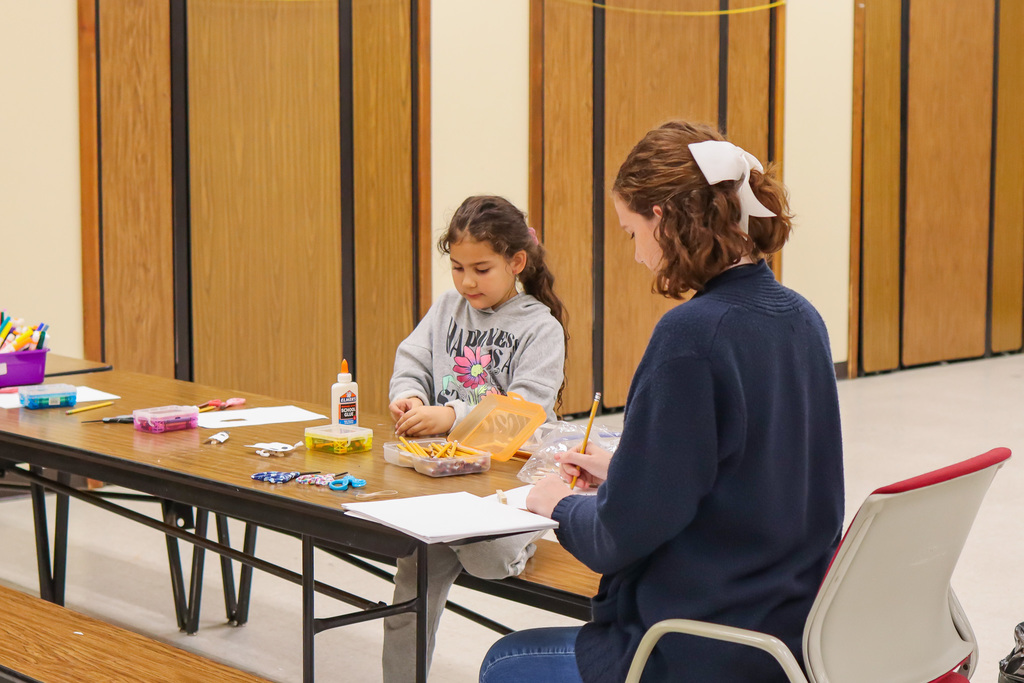 student and teacher working on craft project