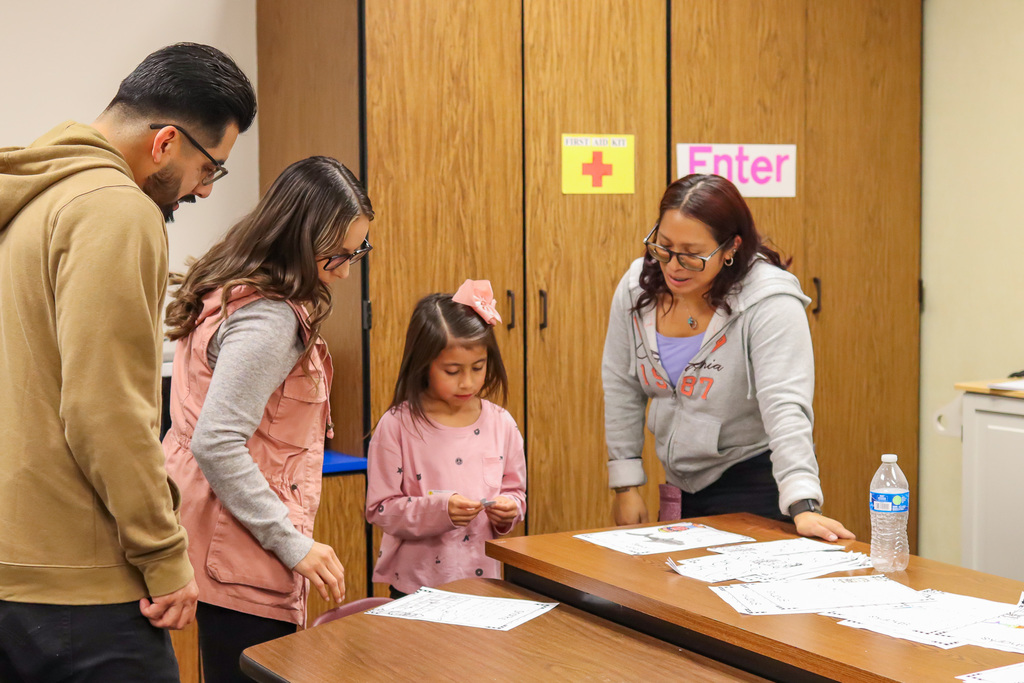 student and family speaking with teacher