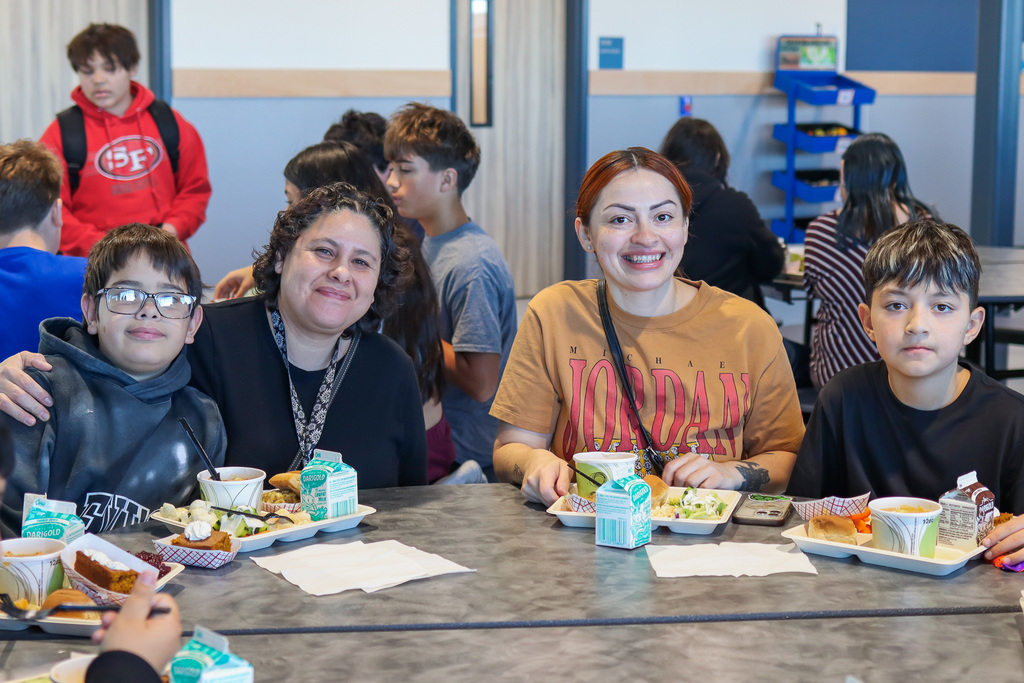 photo of student with family enjoy thanksgiving meal