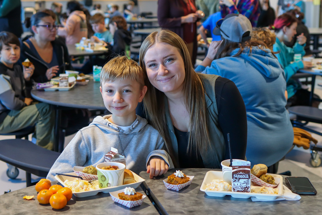photo of student with family enjoy thanksgiving meal