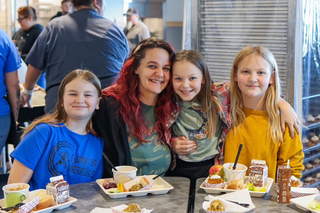 photo of student with family enjoy thanksgiving meal