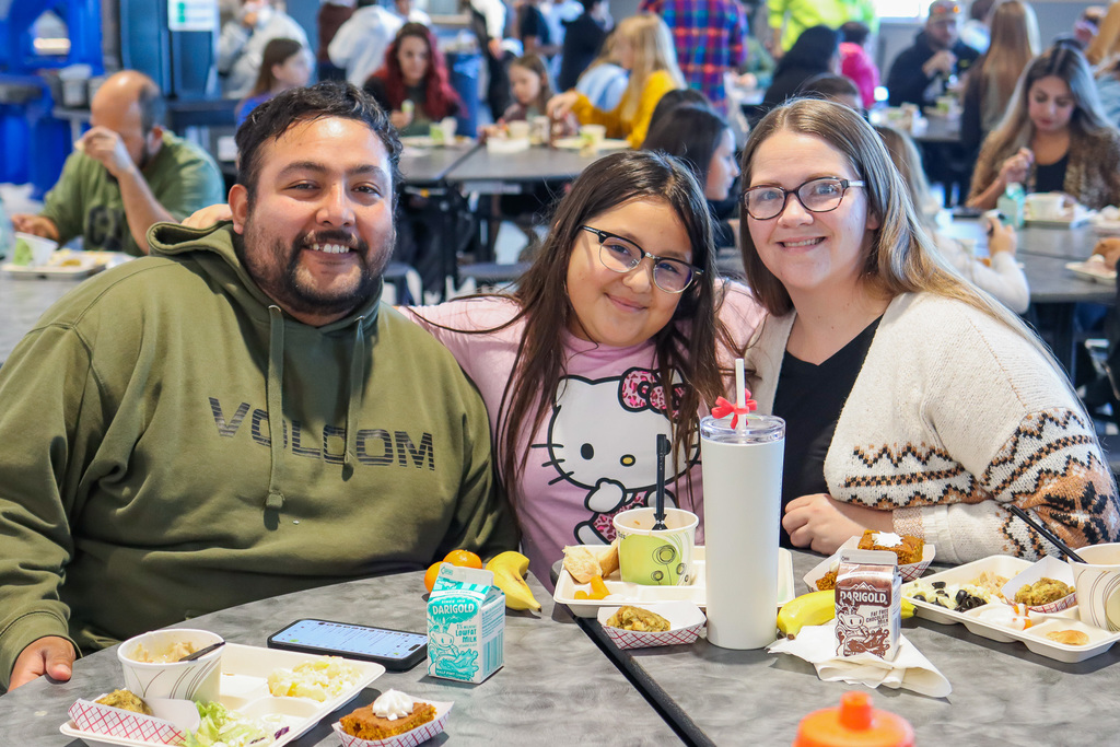 photo of student with family enjoy thanksgiving meal