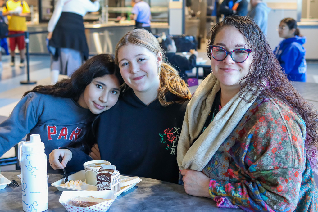 photo of student with family enjoy thanksgiving meal