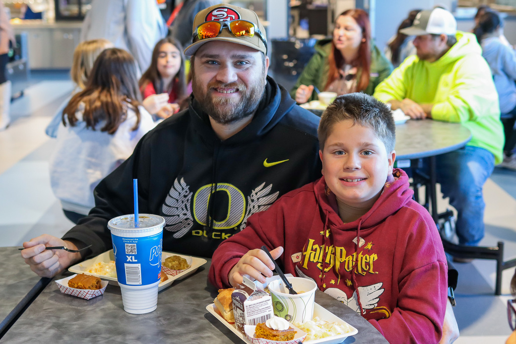 photo of student with family enjoy thanksgiving meal