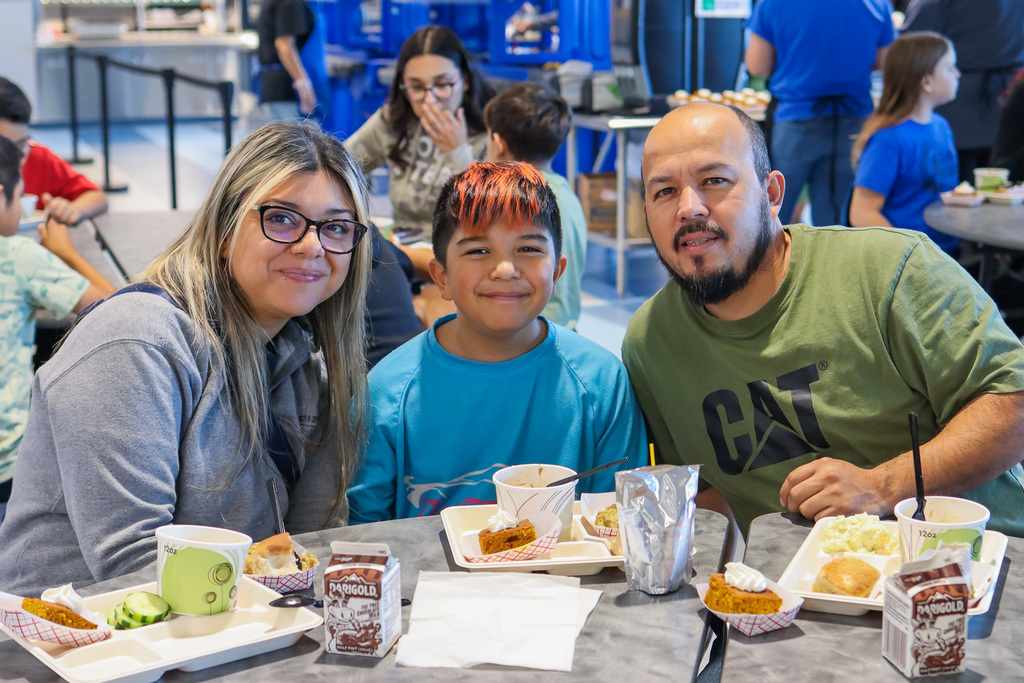 photo of student with family enjoy thanksgiving meal