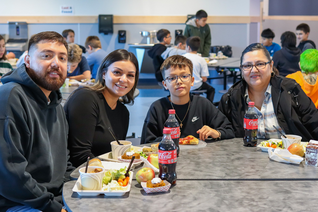 photo of student with family enjoy thanksgiving meal