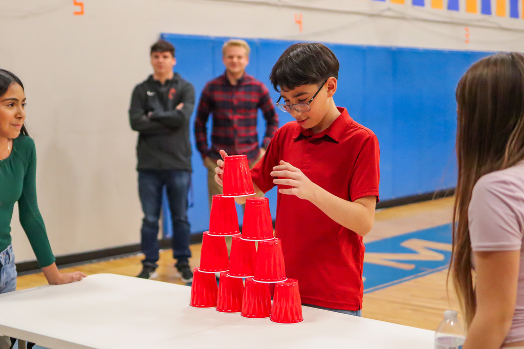 student playing the cup stacking game in assembly