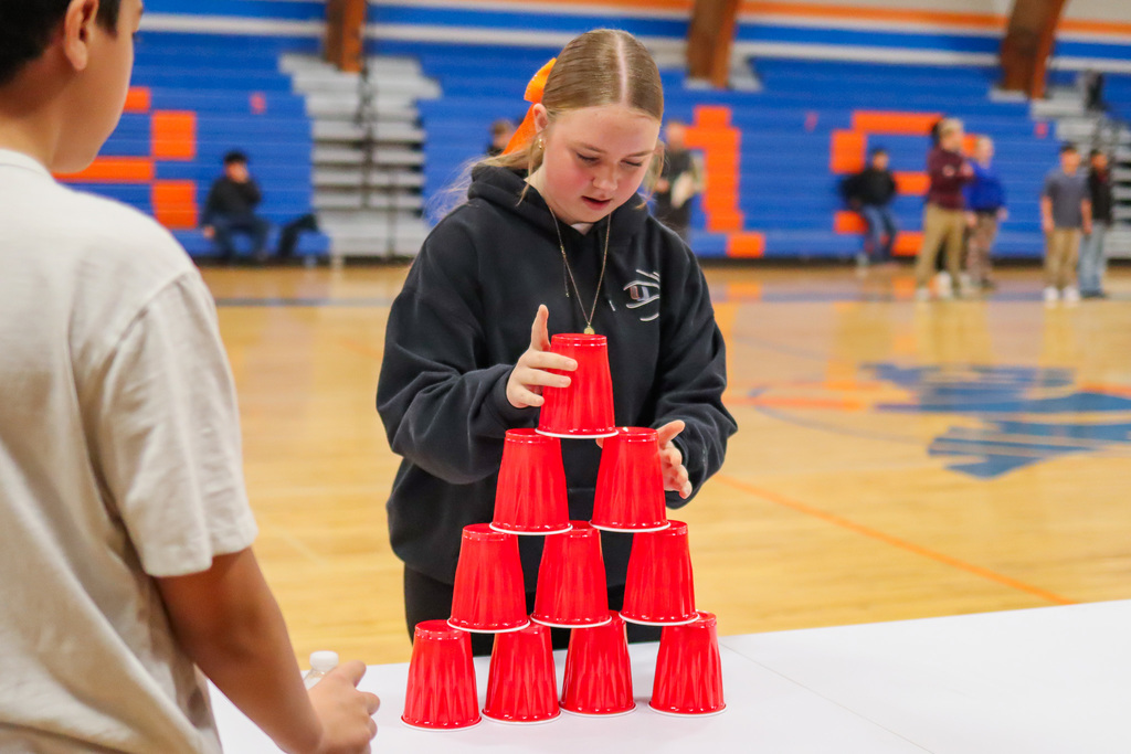 student playing the cup stacking game in assembly