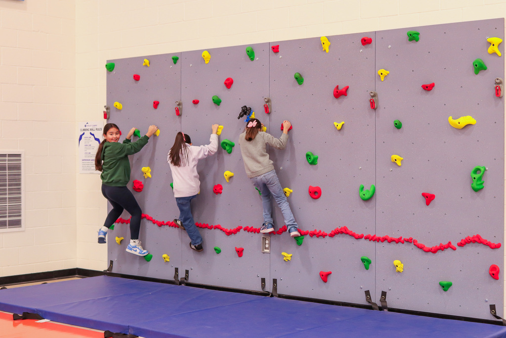 students climbing the rock wall 