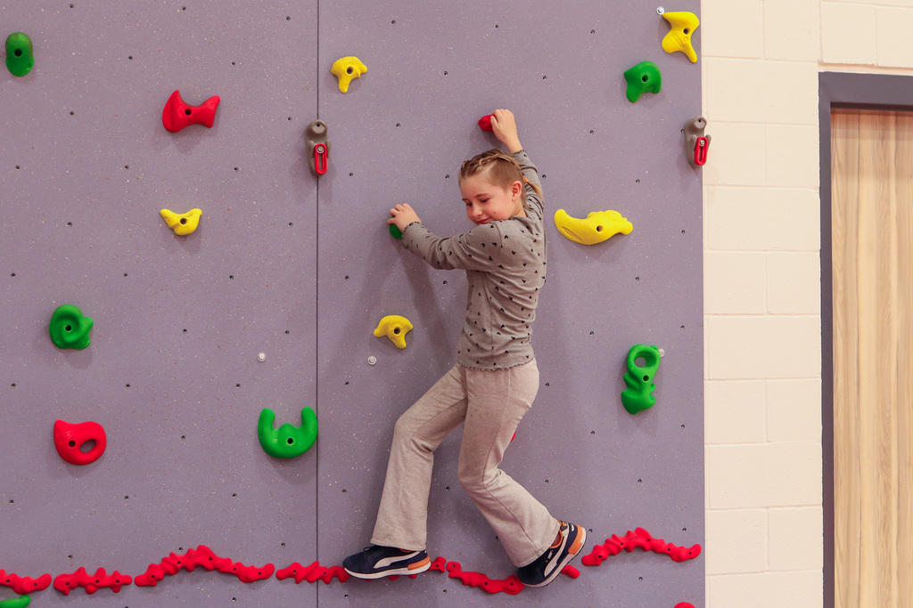 student climbing the rock wall 