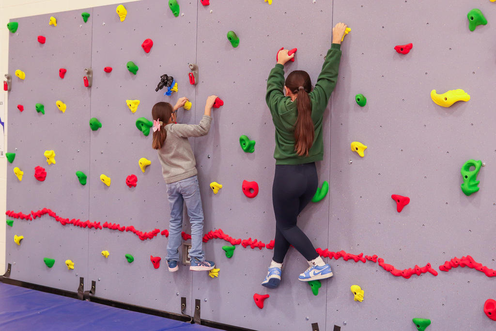 students climbing the rock wall 