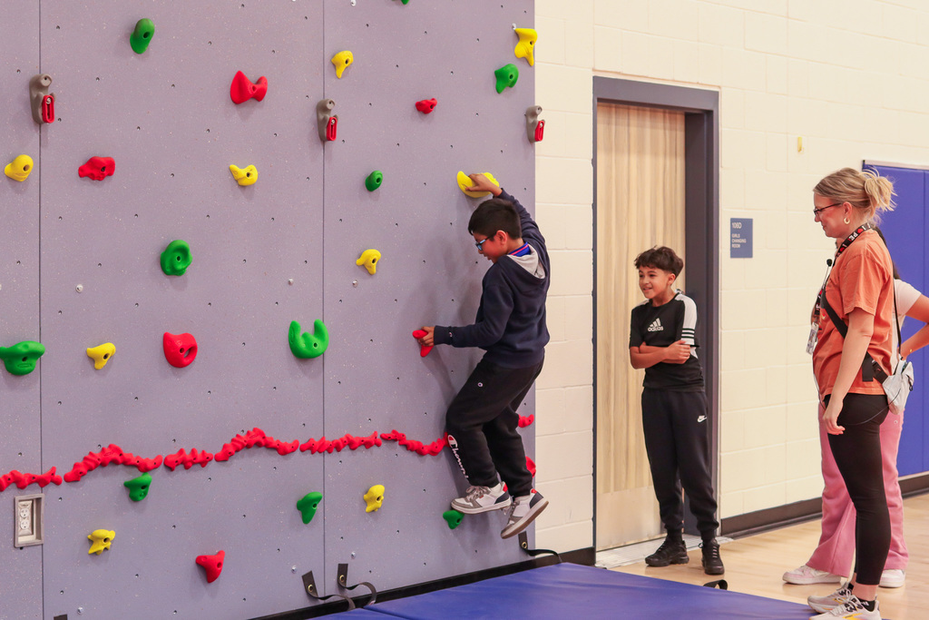 students climbing the rock wall 