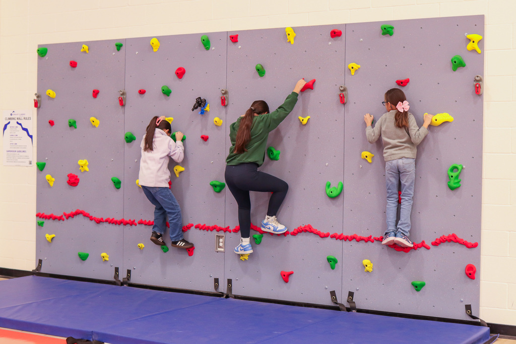 students climbing the rock wall 