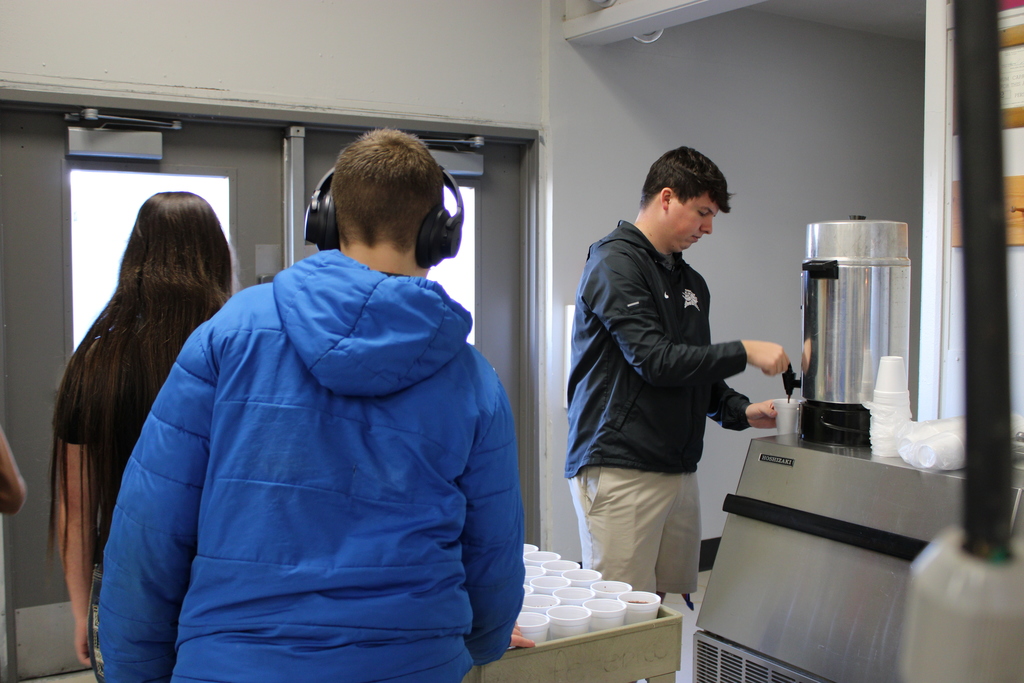 teacher serving students hot chocolate 