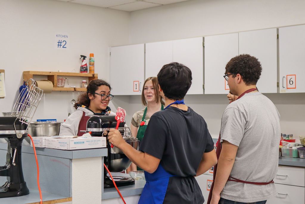 Students waiting for frosting to finish mixing 