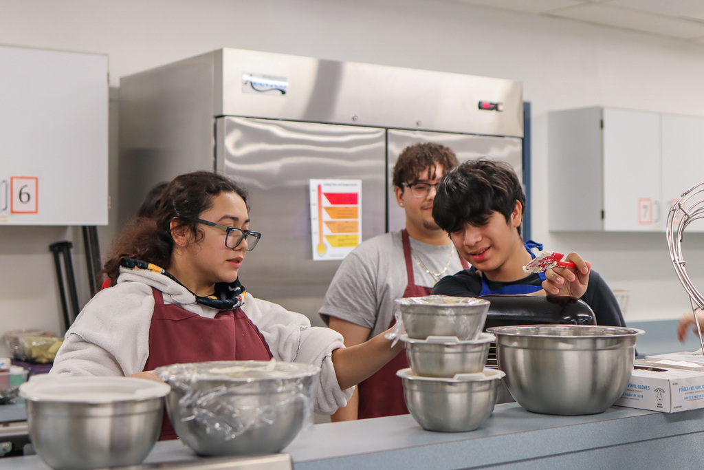students making frosting for cookie boxes