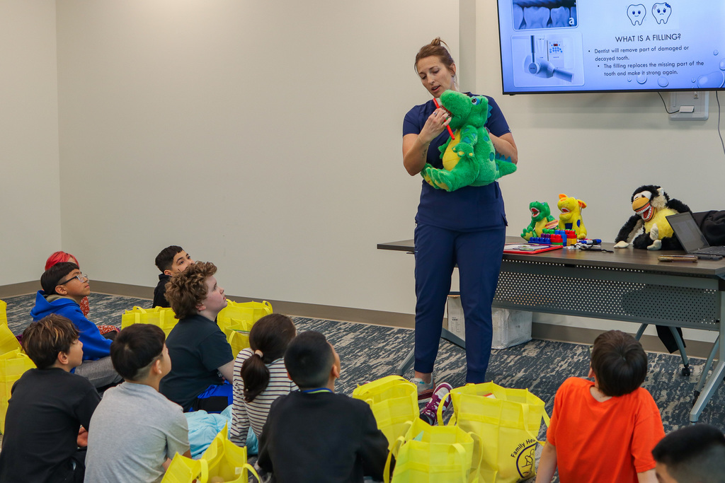 students being taught how to properly brush teeth
