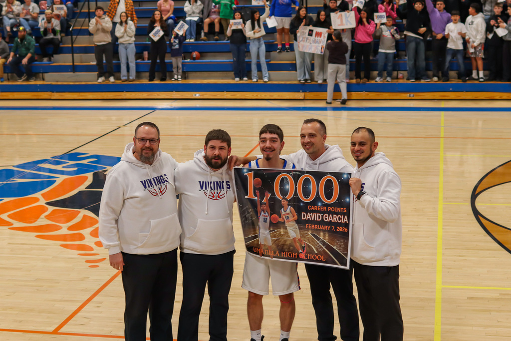 photo of coaches with David holding poster saying he reached 1000 points 
