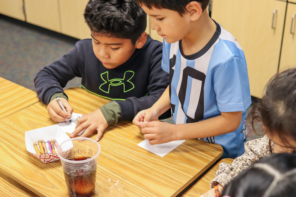 Students coloring an egg drawing to show their predictions