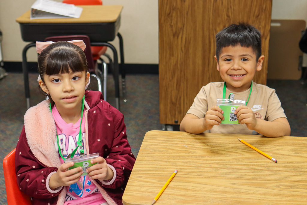 students holding up their badges 