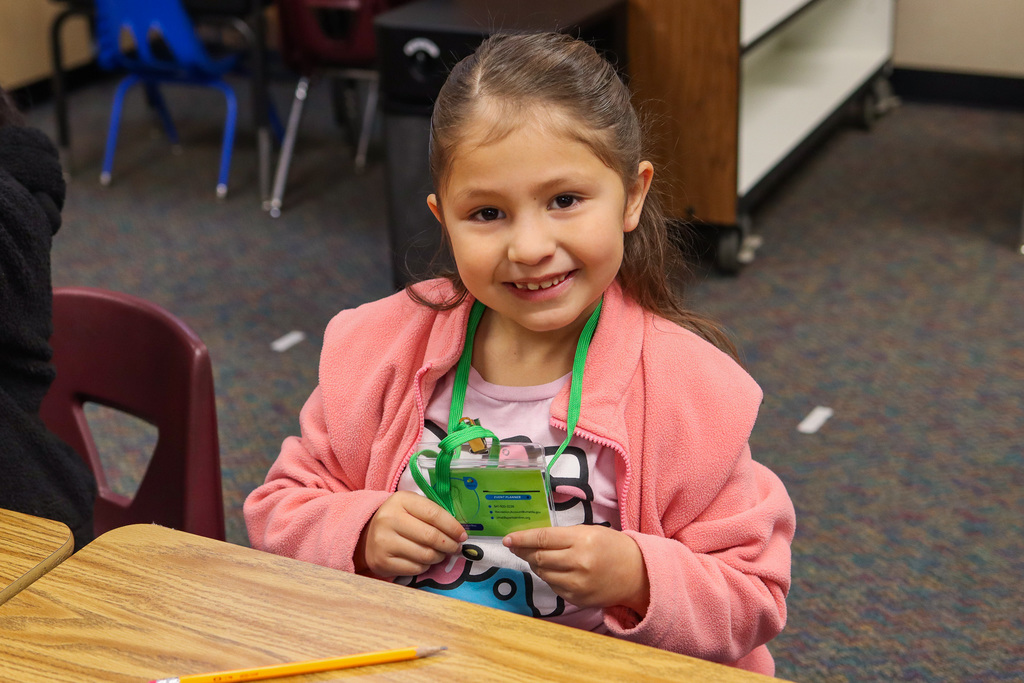 student holding up their badge 