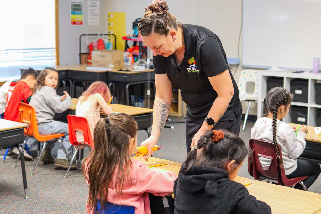Mrs. Carrie handing out supplies to students