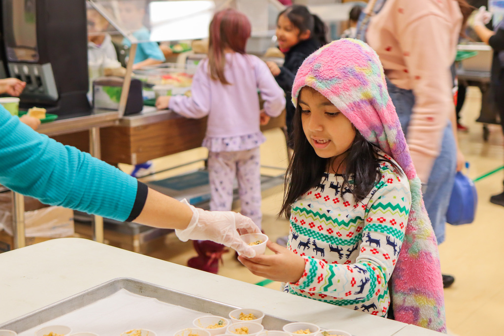 student being handed a Mexican Street Corn sample