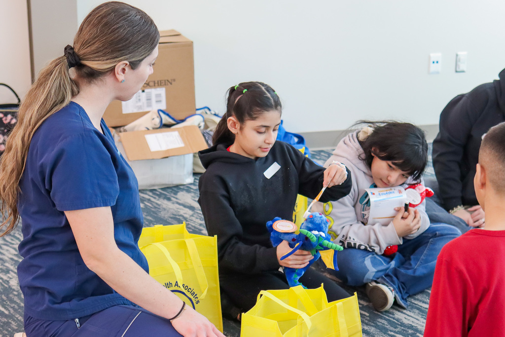 student brushing the teeth on their teddy bear buddy 