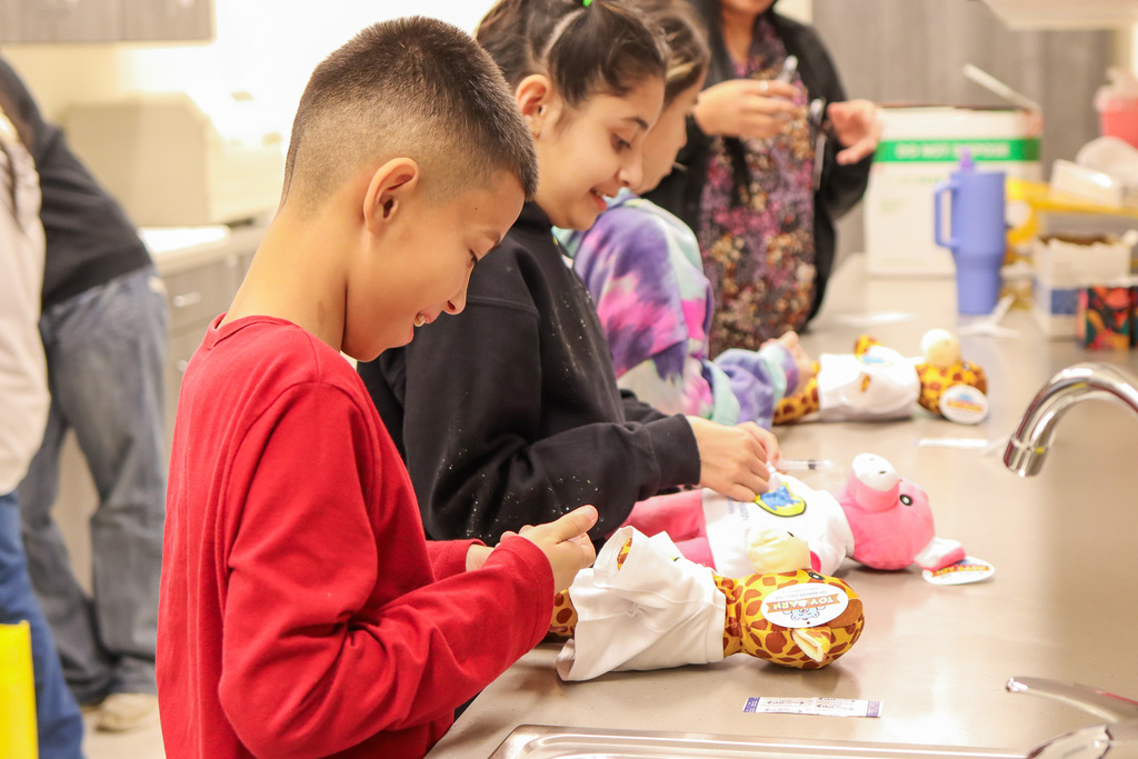 student giving their teddy bear buddy a vaccine 