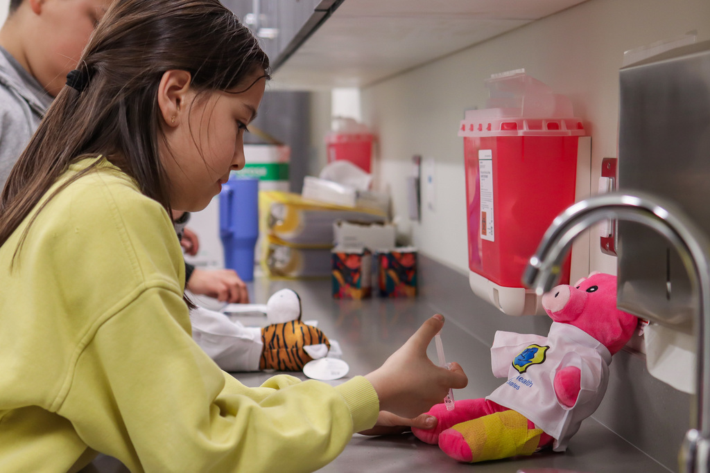 student giving their teddy bear buddy a vaccine 
