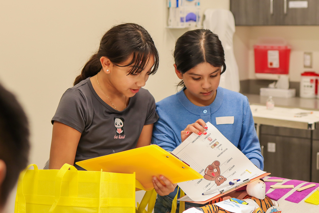 students checking the paperwork on their teddy bear buddy 