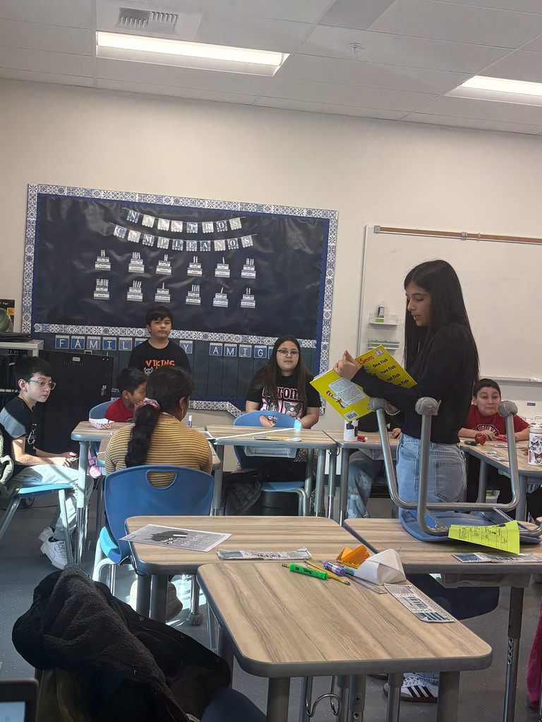 High School student reading to students 