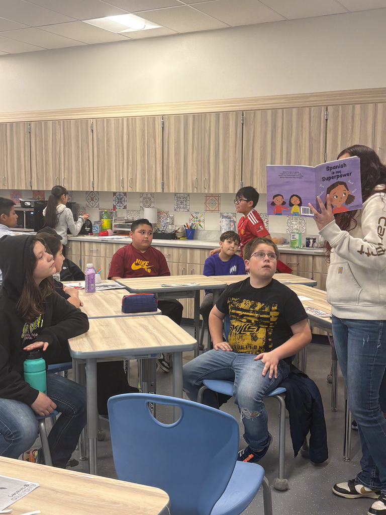 High School student reading to students 