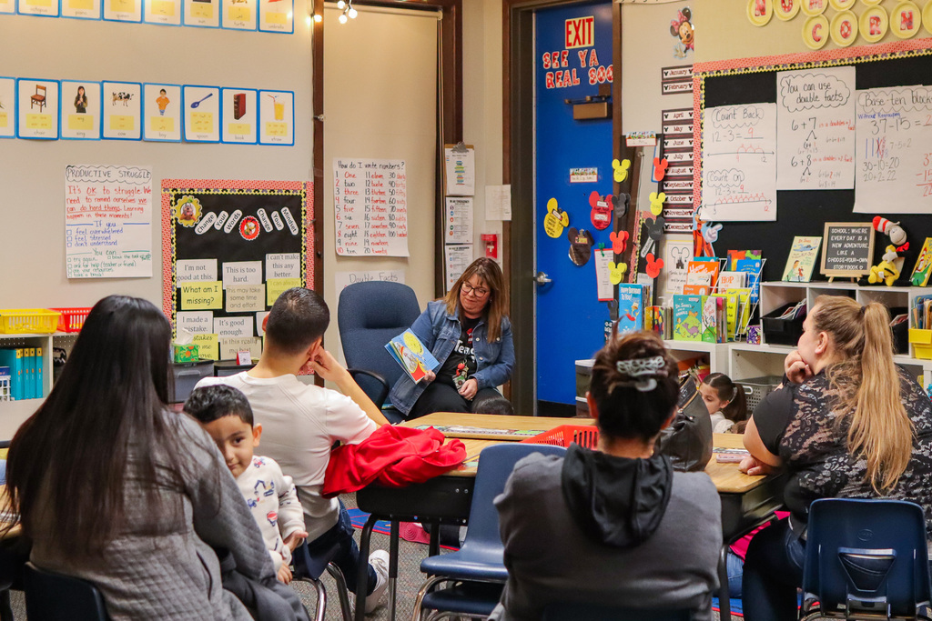 Mrs. Hottman reading book to families