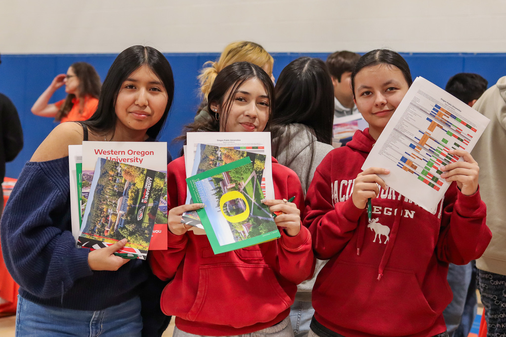 Photo of students holding the program booklets from the universities 