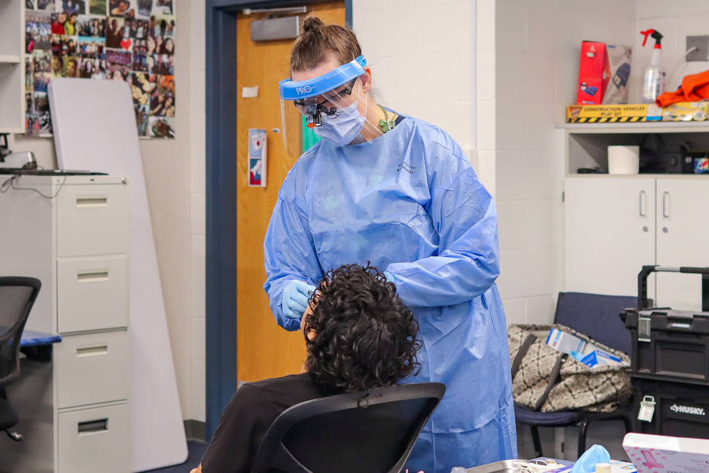 Photo of dental hygienist working on student's teeth 