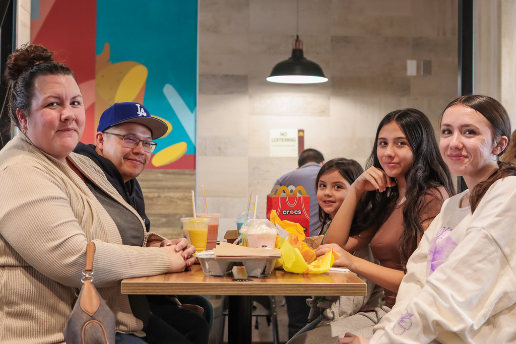 family posing for a photo while enjoying their meal