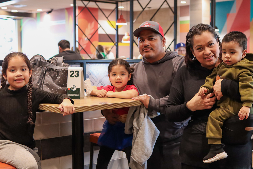 family posing for a photo while waiting for their food 