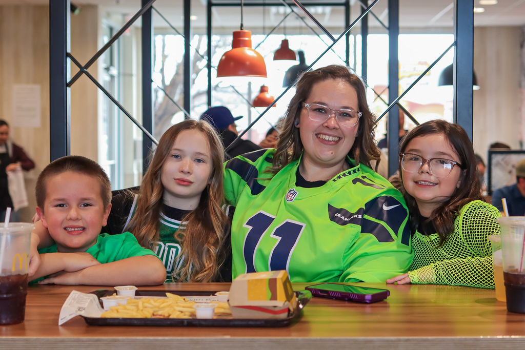 family posing for photo while enjoying their meal